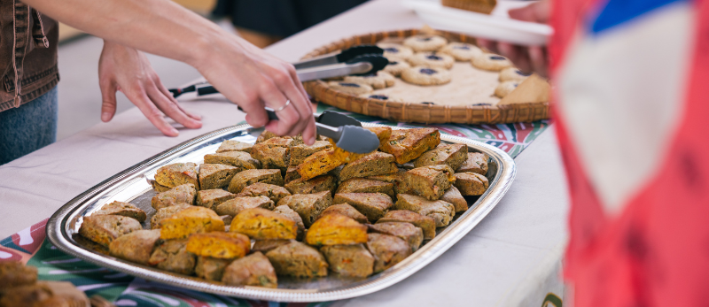 Person using tongs to hand out pastries
